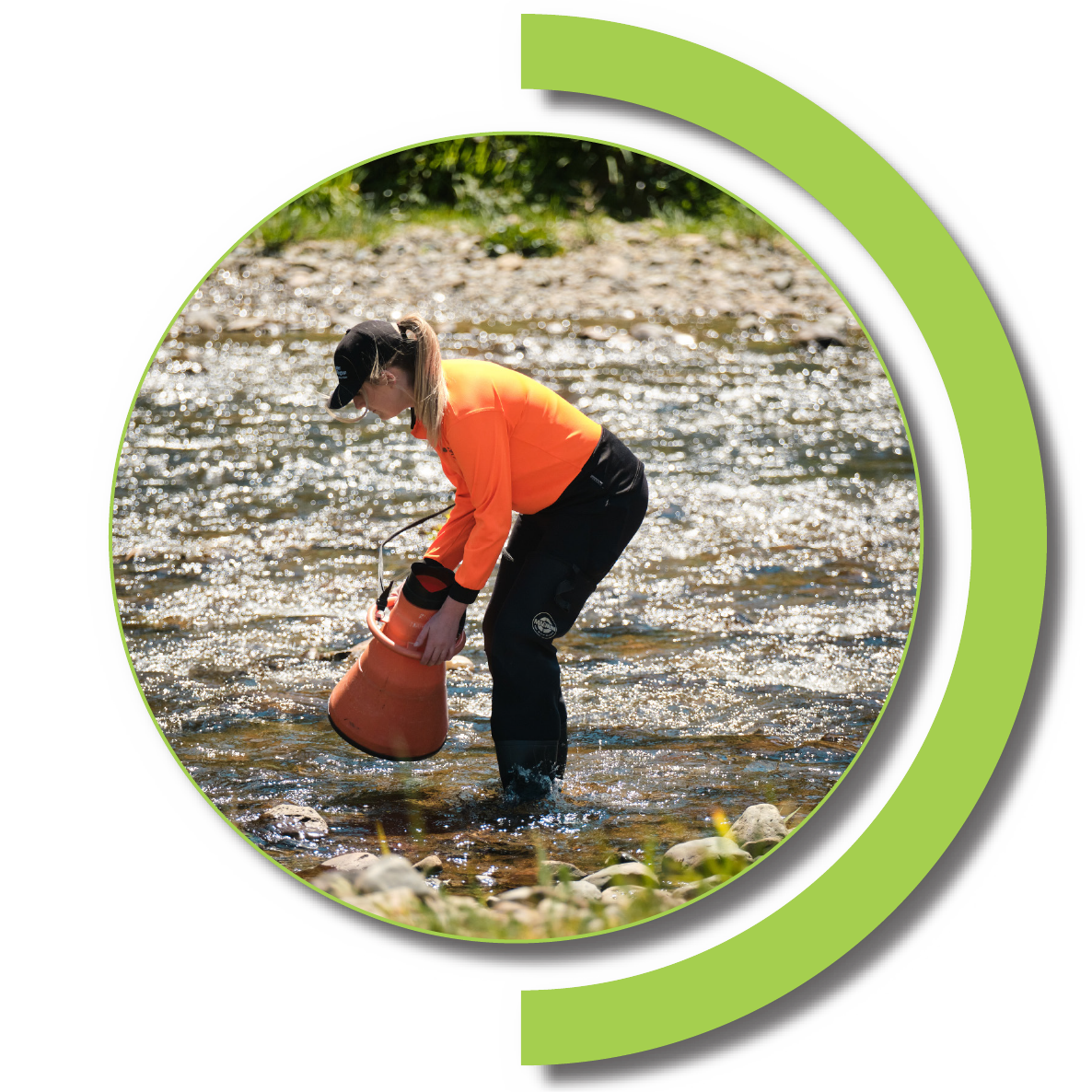 A woman stands in a stream with algae monitoring equipment